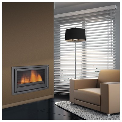 Poltrona bege junto a lareira embutida e candeeiro de pé com cúpula preta num ambiente moderno