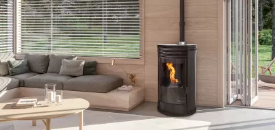 Lareira negra com chama numa sala moderna com sofá cinza, mesa de centro clara e portas de vidro abertas