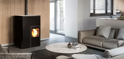 Lareira a pellets preta em sala de estar com móveis cinzentos e parede de madeira clara