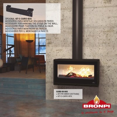 Lareira a lenha preta com vidro frontal e fogo, parede de betão cinzento, chão de cimento polido.