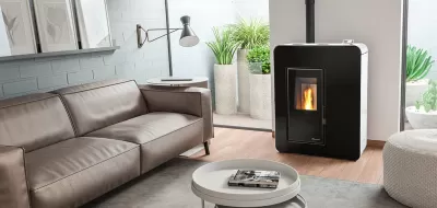 Sala moderna com sofá de couro castanho, lareira preta a pellets e plantas em vasos cinzentos