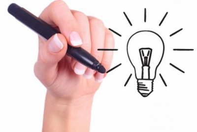 Mão com caneta preta desenhando lâmpada incandescente