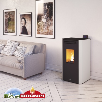 Sala com lareira a pellets Bronpi preta e branca ao lado de sofá cinza com almofadas e quadros na parede