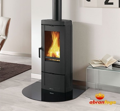 Lareira a lenha preta com vidro frontal e fogo dentro, numa sala moderna