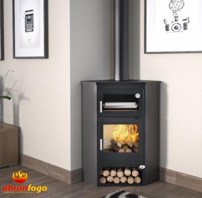 Lareira preta com forno e chaminé junto à parede, madeira armazenada na base