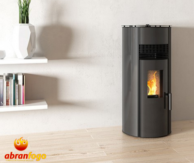 Lareira a pellet cilíndrica cinza com chama visível junto a estante e planta