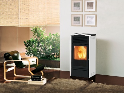 Lareira a pellet preta e branca com chama visível numa sala com cadeira preta, livros, planta e persiana clara