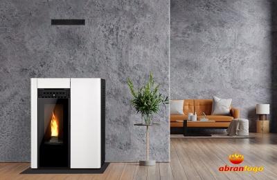 Lareira a pellet branca com chama visível, parede cinzenta, chão em madeira e sofá castanho