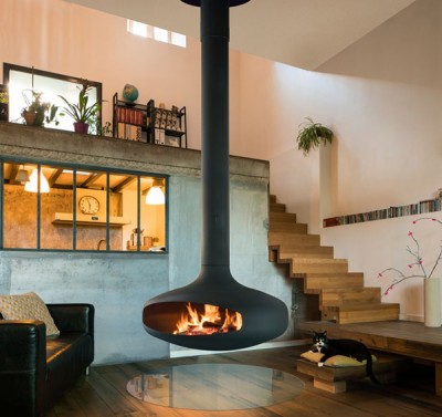 Lareira suspensa preta com fogo numa sala moderna e minimalista