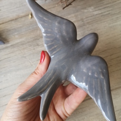Escultura de pássaro cinzenta em cerâmica com acabamento brilhante
