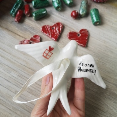 Anjo decorativo branco de cerâmica com fita para pendurar e texto em português