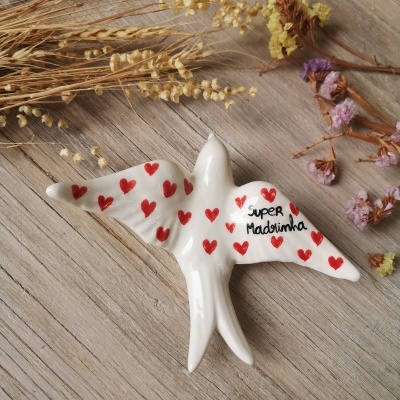 Pássaro decorativo branco em cerâmica com corações vermelhos e texto 'Super Madrinha'.