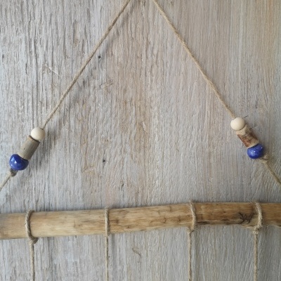 Decoração pendente em corda com bastão de madeira e contas azul e branca