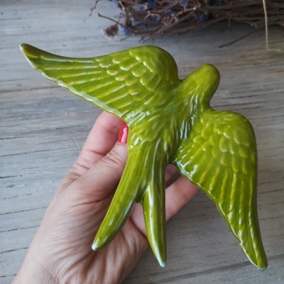 Figura decorativa de pássaro cerâmico verde com asas abertas