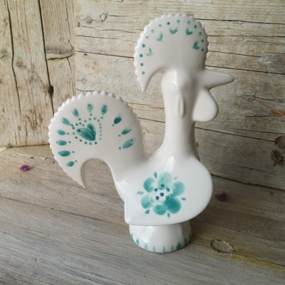 Estátua branca de cerâmica em forma de galo com padrões verdes
