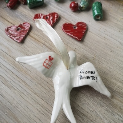 Pendente pássaro cerâmica branco com fita e inscrição, contas vermelhas e verdes, corações decorativos em madeira