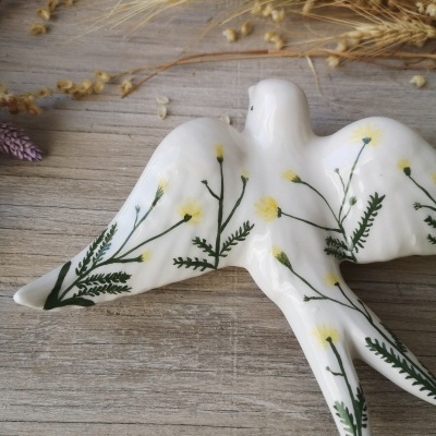 Estatueta de pássaro branca com flores amarelas pintadas