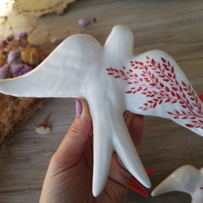 Pássaro decorativo em cerâmica branca com padrão vermelho