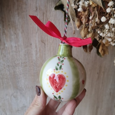 Ornamento de cerâmica redondo pintado à mão com coração vermelho e fita vermelha