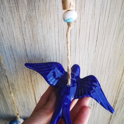 Ornamento pássaro azul em cerâmica pendurado com cordão e contas decorativas