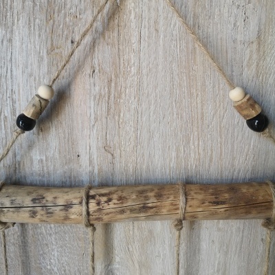Decoração rústica pendurada de madeira e corda com contas em fundo de madeira
