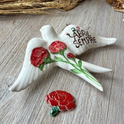 Pomba decorativa branca com flores vermelhas e texto 25 ABRIL SEMPRE.