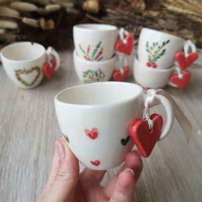 Conjunto de chávenas brancas com corações vermelhos pendurados na pega