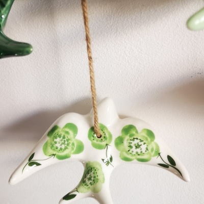 Pêndulo cerâmico branco com pintura verde de flores, suspenso por corda