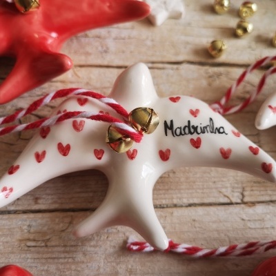 Pássaro decorativo branco com corações vermelhos e guizos dourados com cordão