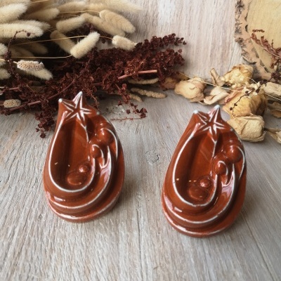 Dois presépios de cerâmica castanha com detalhes em branco em madeira clara com flores secas