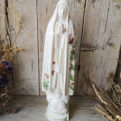 Estátua de Nossa Senhora em porcelana branca com detalhes pintados, sobre base branca