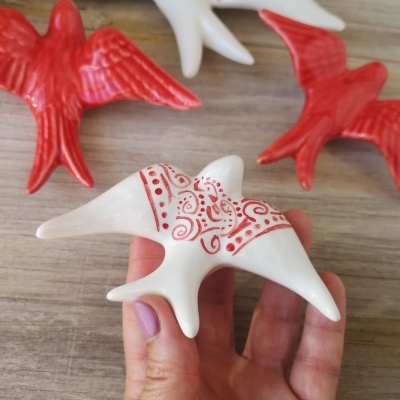 Estrelas-do-mar decorativas cerâmicas vermelhas e brancas sobre mesa de madeira