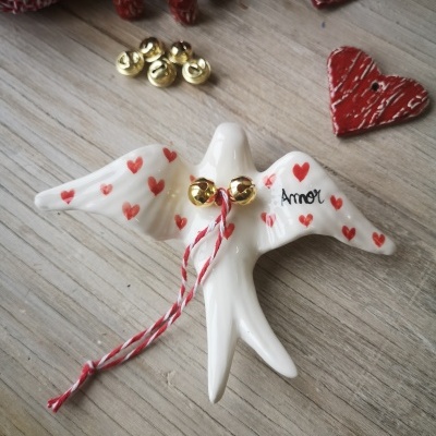 Pássaro de cerâmica branco com corações vermelhos e palavra Amor, com campainhas douradas e cordão vermelho e branco