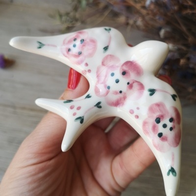 Peça decorativa em cerâmica em forma de pássaro com flores cor-de-rosa