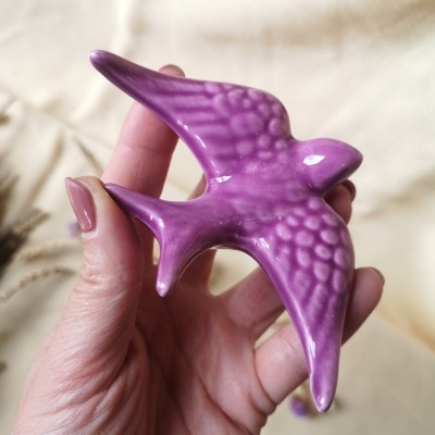 Pássaro decorativo roxo em cerâmica na mão