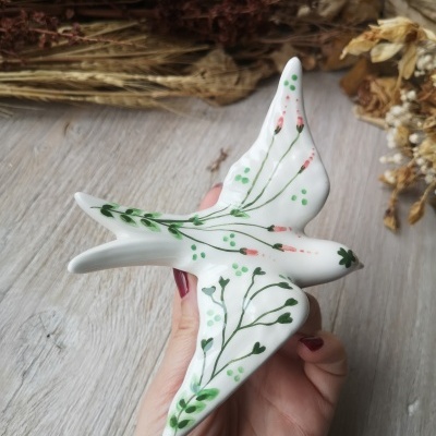 Figura de cerâmica de pássaro branco decorado com ramos verdes e pontinhos cor-de-rosa