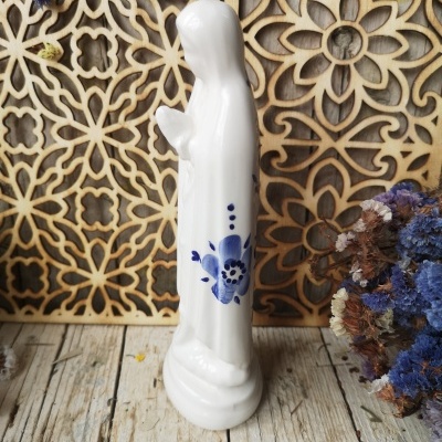 Estatueta branca de cerâmica com flores azuis e padrão floral