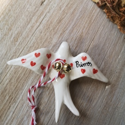 Pássaro decorativo em cerâmica branca com corações vermelhos e guizos dourados