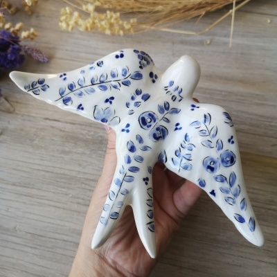 Pássaro decorativo em cerâmica branca com pintura azul floral