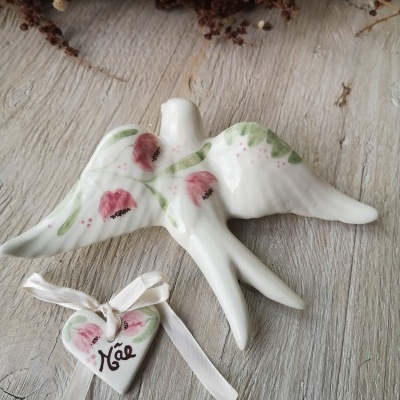 Pássaro de cerâmica com pintura floral e coração com fita e palavra Mãe.