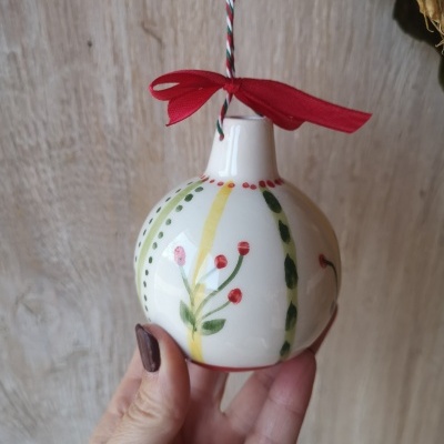 Suspensão de cerâmica com padrões florais coloridos e laço vermelho