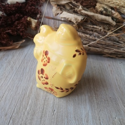 peça cerâmica amarela com flores pintadas e fundo de madeira e flores secas