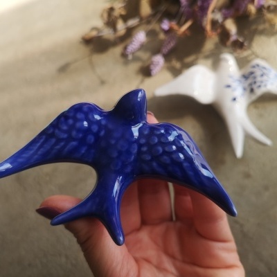Figura decorativa de pássaro em cerâmica azul com padrão de manchas