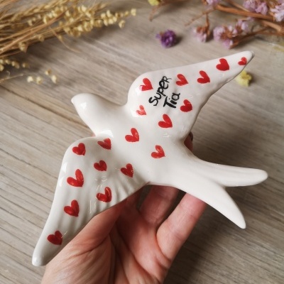 Escultura cerâmica branca de pássaro com corações vermelhos e texto 'Super Tia'