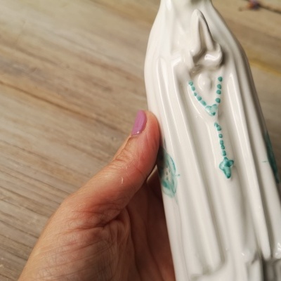 Vaso cerâmico branco com relevo de figura feminina e terço azul