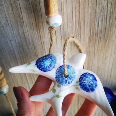 Pendente decorativo em cerâmica branca com flores azuis e cordão de juta.