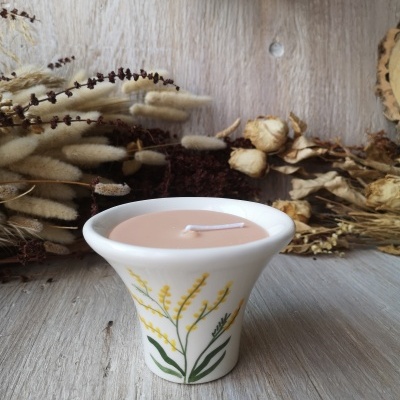 Vela decorativa em cerâmica branca com padrão floral e cera cor de pêssego