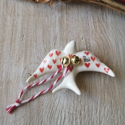Pêndulo branco em forma de ave com corações vermelhos e cordão com guizos dourados