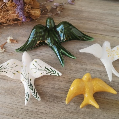 Figuras decorativas de pássaros em cerâmica vidrada em várias cores sobre madeira