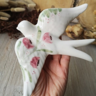 Pássaro decorativo em cerâmica com pintura floral em verde e vermelho